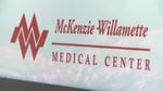 A white sign with red letters, reading, "McKenzie-Willamette Medical Center."