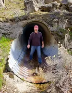 BLM ecologist Charlie Schelz stands in a large culvert that passes under I-5 at Bear Gulch near the California border.