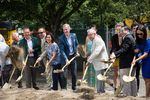 Mayor Ted Wheeler, center, blue suit, and others break ground at the site of a future Ritz-Carlton luxury hotel in Portland, Ore., Friday, July 12, 2019. The hotel has displaced the Alder Food Carts, which had occupied the space since the late 1990s.