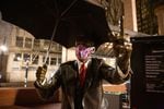 The Umbrella Man statue wears a mask in Pioneer Courthouse Square in Portland, Ore., Saturday, April 18, 2020. Some public health officials have encouraged people to wear masks to slow the spread of COVID-19.