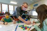 Teacher Eric Marsh works with his third-grade students, (left to right) Sam, Steven, and Sadie. “The thing I hope most for the kids this year is that the harm of the pandemic … and the trauma of the pandemic is lessened to some degree by our joy at being together in class,” Marsh said.