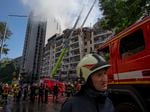 Firefighters work at the scene of a residential building following explosions in Kyiv, Ukraine, on June 26, 2022.