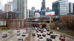 Traffic flows along Interstate 90 highway as a Metra suburban commuter train moves along an elevated track in Chicago.
