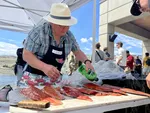 Ira Stevenson preps salmon filets for the salmon bake after a First Salmon ceremony at Chief Joseph dam in north central Washington.