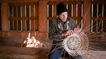 Jordan Mercier weaves gathered hazel sticks into a basket at the Chachalu Museum and Cultural Center in Grand Ronde in June 2022.