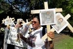 Nancy Pablo, with Alianza Latina International, holds crosses with photographs of victims of the Rob Elementary School shooting as she walks across the street from the National Rifle Association's annual meeting at the George R. opposes with.  May 27, 2022, in Houston.