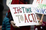 A close up of a protester's sign, which reads "It's time to act!" in bright colors.