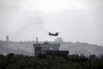 A U.S. Chinook helicopter flies over the U.S. Embassy in Kabul, Afghanistan, Sunday, Aug. 15, 2021. Helicopters are landing at the U.S. Embassy in Kabul as diplomatic vehicles leave the compound amid the Taliban advanced on the Afghan capital.
