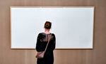 A woman stands in front of an blank canvas hung up at the Kunsten Museum in Aalborg, Denmark, in 2021. Danish artist Jens Haaning sent the museum blank canvasses under the title Take the Money and Run.